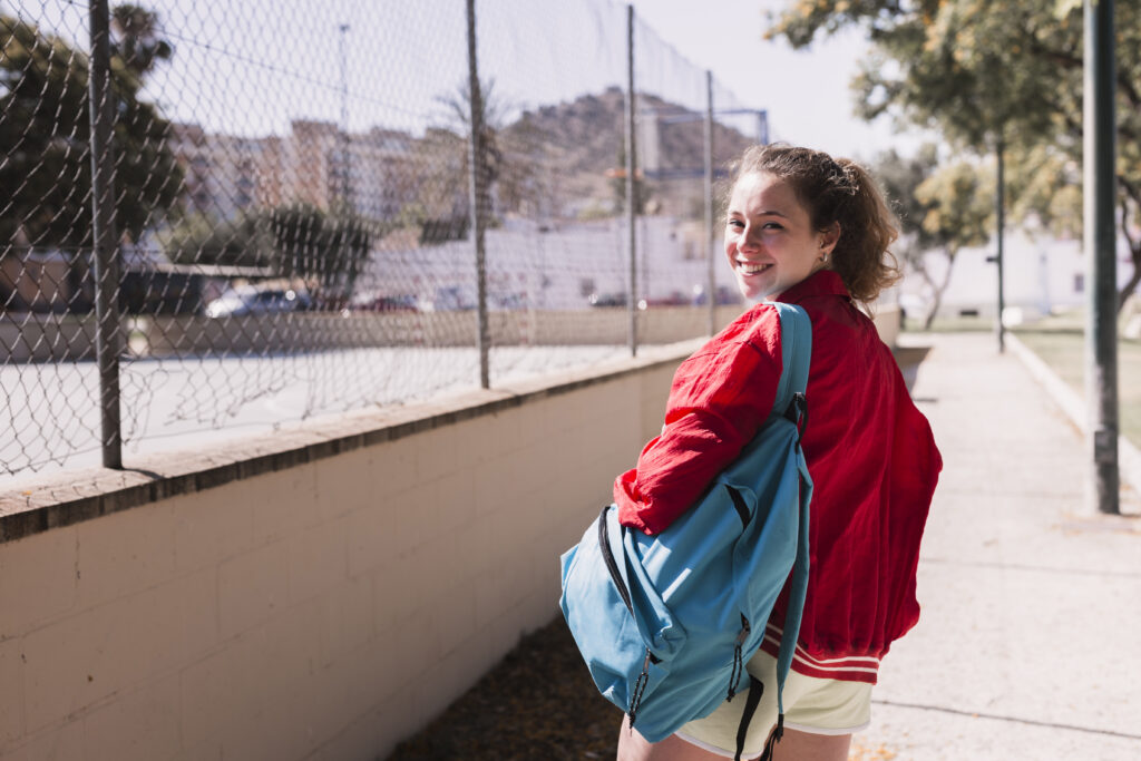 female poses young girl walking near sportsground