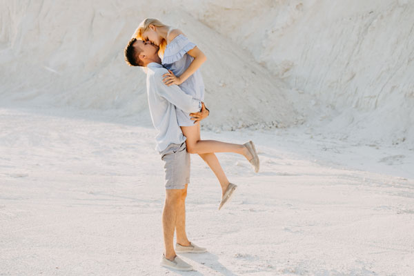 Couple poses Lifting Legs up While They Kiss